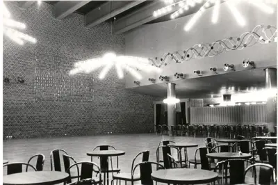 Medborgarhus.
Interiör av stor sal med kafébord.