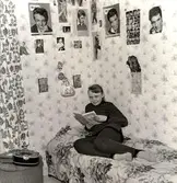 Tonårsflicka i sitt rum. Idolbilder på Tommy Steele och Elvis Presley på väggarna. 