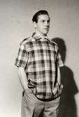 Italienskt herrmode 1953. Manlig modell iklädd rutig kortärmad skjorta, bommulsbyxor.