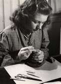 Kvinna i arbete vid uppmaskningsateljén på Nordiska Kompaniet i februari 1943.