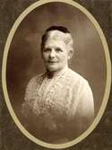 Porträtt av Agnes Hedvig Charlotta Lagerstedt, svensk folkskollärare och filantrop. Hon är iklädd broderat blusliv med brosch i halsen och en tunn sjal över axlarna.