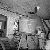 Äldre kvinnor bredvid stort bykkar, Ovesholms brygghus. 