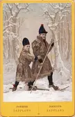 Ateljébild. Man och pojke i samiska dräkter. Handkolorerad.