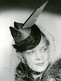 Porträtt av kvinna med tvåfärgad stråhatt med flor och fjäderpenna, från Suzanne Talbot.