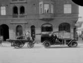 Brandkåren på Nygatan. Bilen står framför Centralpalatset. Bogsering av ångspruta med en nyinköpt begagnad personbil som inköpt i Karlstad samt därefter, omändrats till brandbil, Winstone (110Hk).