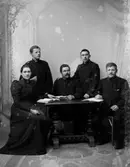 Frälsningsarmén. Ateljebild. Fem personer i uniform vid ett bord.