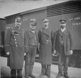 Grupporträtt - från vänster konduktör, lokförare, överkonduktör och stationskarl på Uppsala centralstation, Uppsala 1890-tal