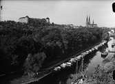 Vy över Uppsala i oktober 1949 med Fyrisån, småbåtshamn och Stadsträdgården i förgrunden. Uppsala slott och Uppsala domkyrka i bakgrunden