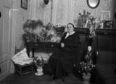 Födelsedagsporträtt  - kvinna i hemmiljö, sannolikt Uppsala, 1935