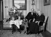 Födelsedagsporträtt - äldre kvinna och man i hemmiljö, sannolikt i Uppsala 1942