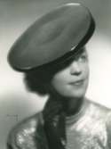 Fb, Porträtt av kvinna i hatt av Rose Valois. Svart filt med lackgarnering.