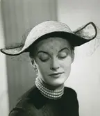 Porträtt av kvinna i hatt med flor, av Gilbert Orcel.