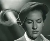 Porträtt av kvinna i senapsgul velourhatt med paradisfantasie i samma färg. Modell från Maison Claude St. Cyr.