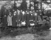 Gruppbild, skolfoto (?) i utomhusmiljö. skog