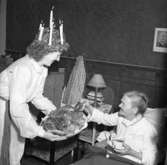 Lucia bjuder äldre kvinna på lussekaffe år 1947