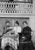Tre damer tar en kaffepaus nedanför en veranda