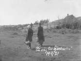 Två kvinnor i fotografens familj vandrar iväg till Fjällbacka den 11 april 1921