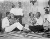 Ett sällskap på fyra personer, varav en är Johan Börjesson-Eld, sitter på golvet, de två kvinnorna matar de två männen