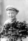 Ateljefoto på pojke med blomsterfång.
