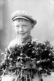 Ateljefoto på pojke med blomsterfång.