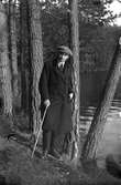 Gustav Andersson med käpp i handen på promenad i barrskogen.