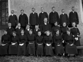 Konfirmandgrupp, sannolikt Veckholm, Uppland, troligen 18 april 1914. I mitten komminister Mats Åmark (1882-1973).