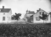 Torggatan, Enköping, vy från sydöst och från något bortom korsningen med Östra Ringgatan. Huset med tornet kallades folkligt för Bondkyrkan.