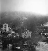 Vid stora fallen i Huskvarna ligger, uppe till vänster, byggnaden som idag är Husqvarna Fabriksmuseum sedan 27 april 1993, och inryms i det hus som fram till 1940-talet var vapenverkstad. Till vänster syns en del av Slottsvillan. I förgrunden går Hakarpsvägen med bro över vattnet. Bilden är från 1870-talet.