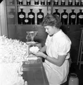 På apoteket på Rosenborgsgatan i Huskvarna sitter Yvonne Eriksson och fyller på förpackningar med doktor Hjortons pulver. Det framställdes för att motverka spanska sjukan, men kom att användas av många arbetare på Husqvarna AB som ett uppiggande medel. Med tiden visade det sig vara beroendeframkallande och kunde orsaka allvarliga skador på bland annat njurar och lever.