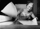 Porträtt av en kvinna som sorterar papper på Papyrus i Mölndal på 1950-talet.