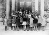 Flickor i fjärde klass, stående framför Centralskolans port i Mölndal år 1931.