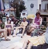 Solande på en terrass. Semesterresa med elever från Streteredshemmet på 1970-talet.