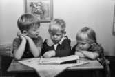 Bosgårdens barnträdgård 1938-1945. Tre barn som tittar i en bok.