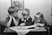 Bosgårdens barnträdgård 1938-1945. Tre barn som tittar i en bok.