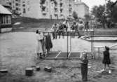 Lekande barn på en lekplats utanför ett daghem. Guldheden i Göteborg 1945-.