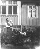 En man håller ett barn i famnen på Fässbergsgatan 31 i Toltorpsdalen. 1920-tal.