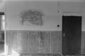 Dokumentation av väggmålningar i Ryets bibliotek 1992. Biblioteket har tömts på grund av nedläggning. Här är en målning av Mosstorpet i Lackarebäck, långt upp i Svejserdalen.