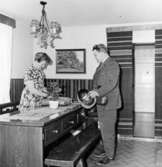 Lantbrevbärare Cyril Falk lämnar ett paket hemma hos fru Astrid Andersson, Hunshult.

Bilkåkande lantbrevbäraren Cyril Falk på linjen Lönsboda-Hunshult-Björkhult-Lönsboda.  Foton maj 1961.