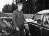 Post lämnas i Traneboda. Bilkåkande lantbrevbäraren Cyril Falk på linjen Lönsboda-Hunshult-Björkhult-Lönsboda.

Foto maj 1961.