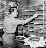 Lantbrevbärare Ingvar Carlsson förbereder brevbäringsturen, på postexpeditionen i Åkersberga.  Augusti 1961.