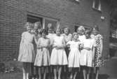 Unga kvinnliga elever står utomhus vid Skolhemmet Stretered. 1950-tal.