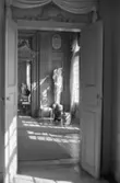 Dokumentationsbilder från Gunnebo slott våren 1992. Inredningsmiljö, konstföremål och möbler av varierande slag. Här ses en korridor av rum varav det mittersta har en staty och höga vaser.
