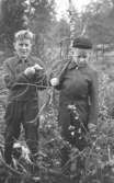 Bröderna Leif och Alf Garthman står i ett skogsområde i Mölndal, 1950-tal.