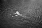 En kvinna, på utflykt med Katrinebergs daghem, simmar omkring på djupt vatten.