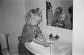 Jasmine tvättar händerna i handfatet inne på en toalett. Lille Skutt, Katrinebergs daghem, 1992.