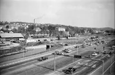 Mölndals nedre med spårvagnsspår, bilväg, järnväg och kulverteringen av Mölndalsån, innan motorvägen och bron byggdes. Skorstenen står på Papyrus-området. Utsikt från Folkets hus mot sydost, 1960-tal.