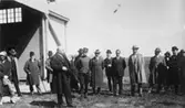 I samband med öppnandet av flygrouten Malmö - Hamburg. 
Stadsfullmäktiges i Malmö ordförande N. Persson överlämnar här
flygplatsen till flygbolaget.  Mannen i mitten utan hatt och rock, är
kapten Carl Florman.