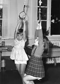Två flickor i rep som hänger från taket vid Holtermanska daghemmet 1953.