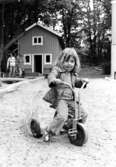 Ett barn som sitter på en trehjuling. Holtermanska daghemmet 1973.