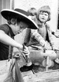 Tre barn som leker med verktyg utomhus. Holtermanska daghemmet juni 1974.
